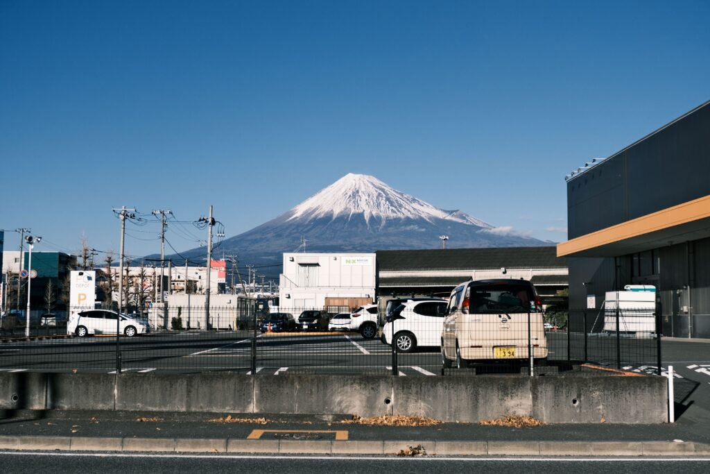 Stunning view of snow-capped Mount Fuji visible from a parking lot in Shizuoka, Japan.