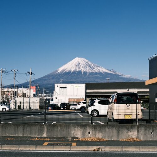 Stunning view of snow-capped Mount Fuji visible from a parking lot in Shizuoka, Japan.