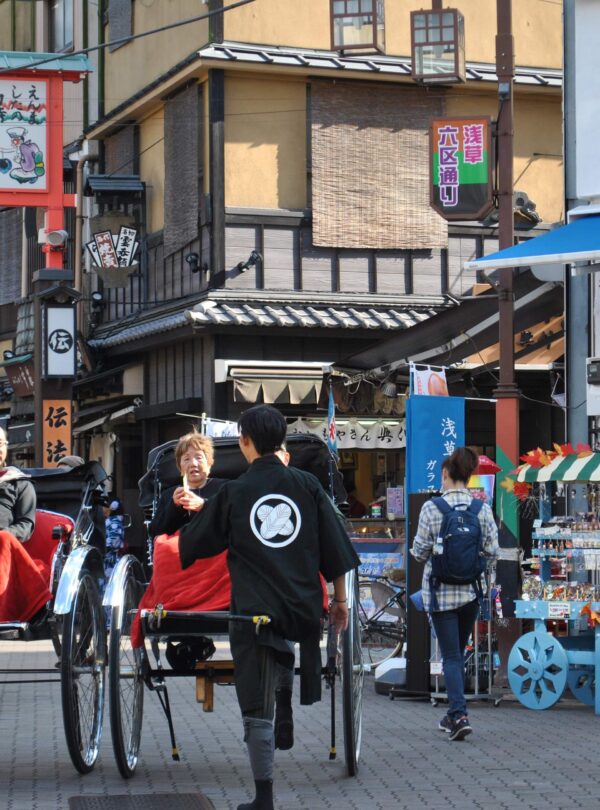 Vibrant street scene with traditional rickshaws and bustling shops in a lively marketplace.