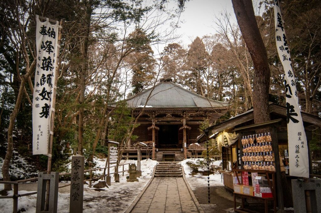 Trip Search Result A tranquil scene of a traditional Japanese temple surrounded by trees and snow.