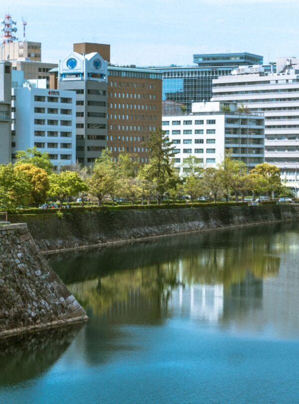 City skyline reflected in a moat surrounded by greenery. Featured in the modern Japanese cityscape.