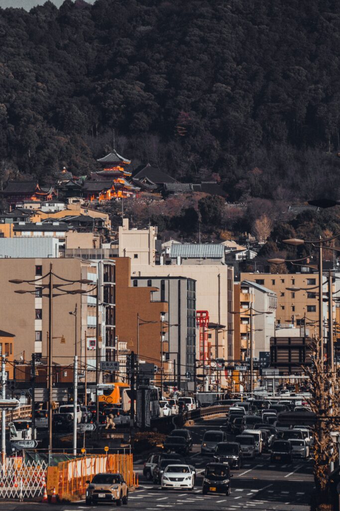 Trip Search Result A vibrant view of Kyoto streets with Kiyomizu-dera temple nestled in lush hills.