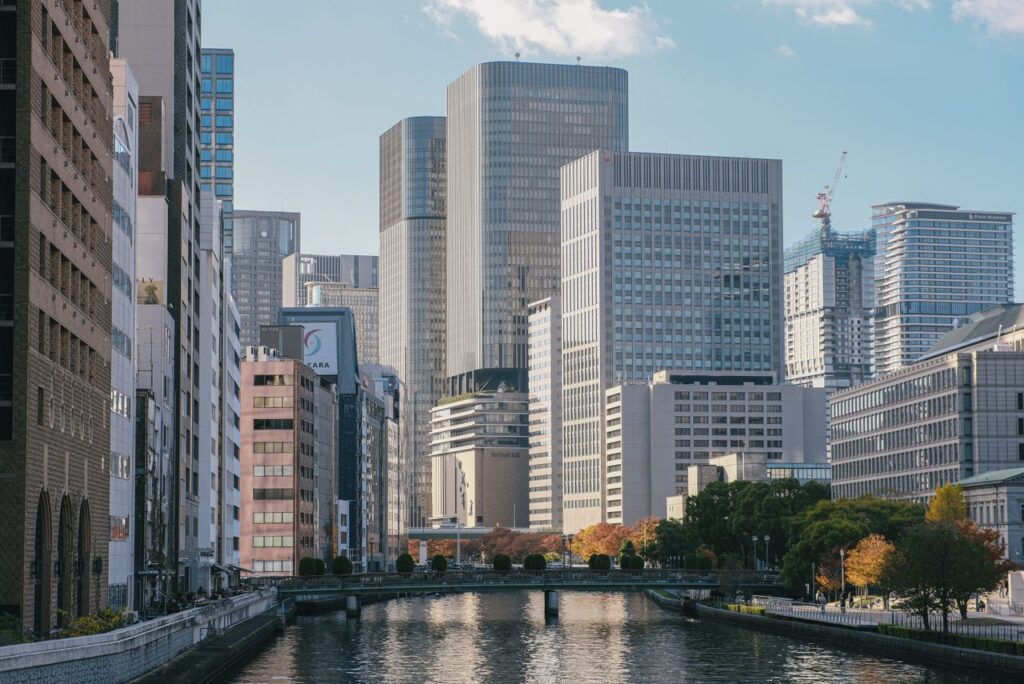 Trip Search Result A modern urban landscape featuring tall skyscrapers and a quiet river, offering a peaceful city view.
