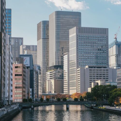 A modern urban landscape featuring tall skyscrapers and a quiet river, offering a peaceful city view.