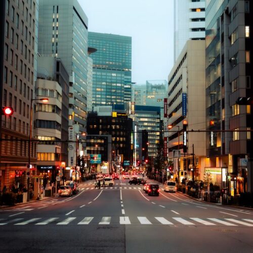 Bustling Tokyo street at dusk showcasing modern architecture and city life.