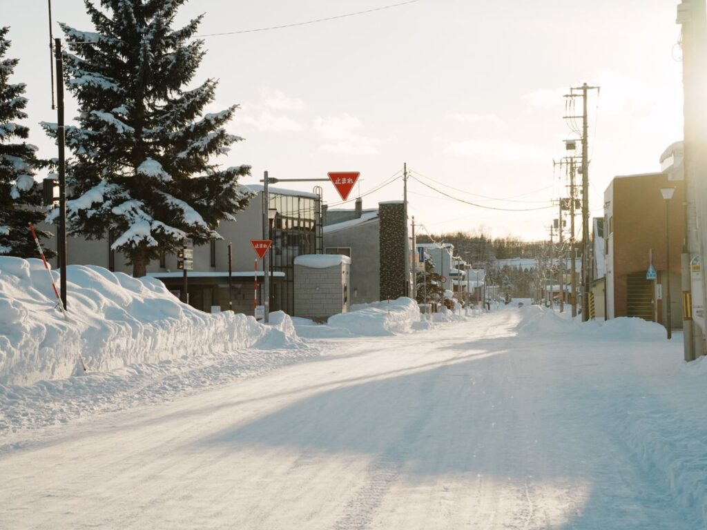 A serene winter street view with snow-covered surroundings in Hokkaido, Japan.