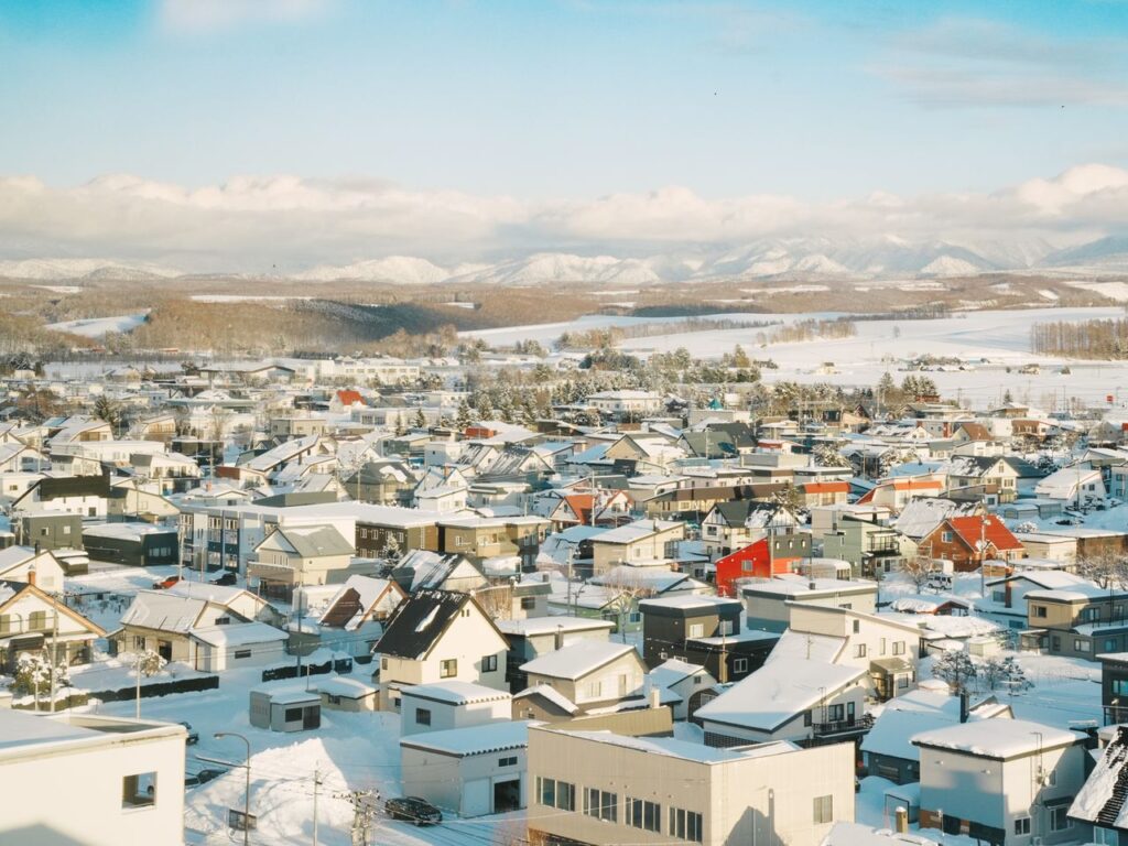 Aerial view of a snow-covered village in Hokkaido, Japan, showcasing scenic winter landscapes.