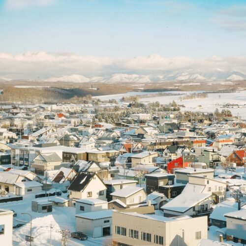 Aerial view of a snow-covered village in Hokkaido, Japan, showcasing scenic winter landscapes.