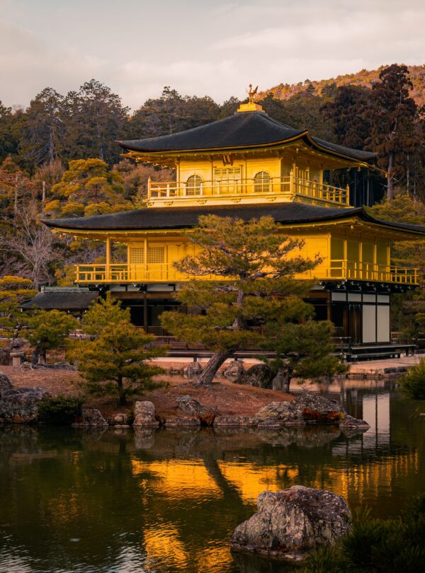 Kinkaku-ji Temple at sunset, reflecting on a serene pond in Kyoto, Japan.