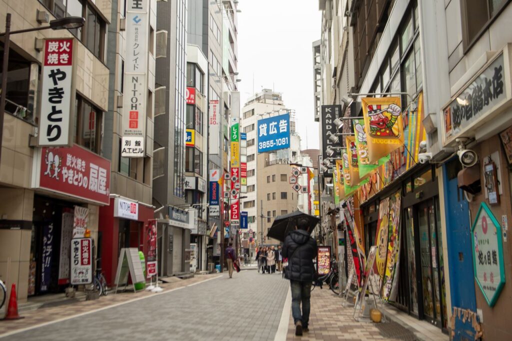 Trip Search Result Vibrant Tokyo street scene with pedestrians, neon signs, and urban atmosphere.