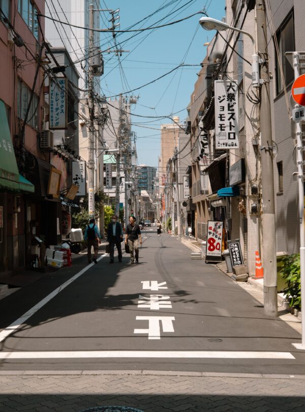 A quiet street in Tokyo, showcasing urban life and traditional architecture on a sunny day.