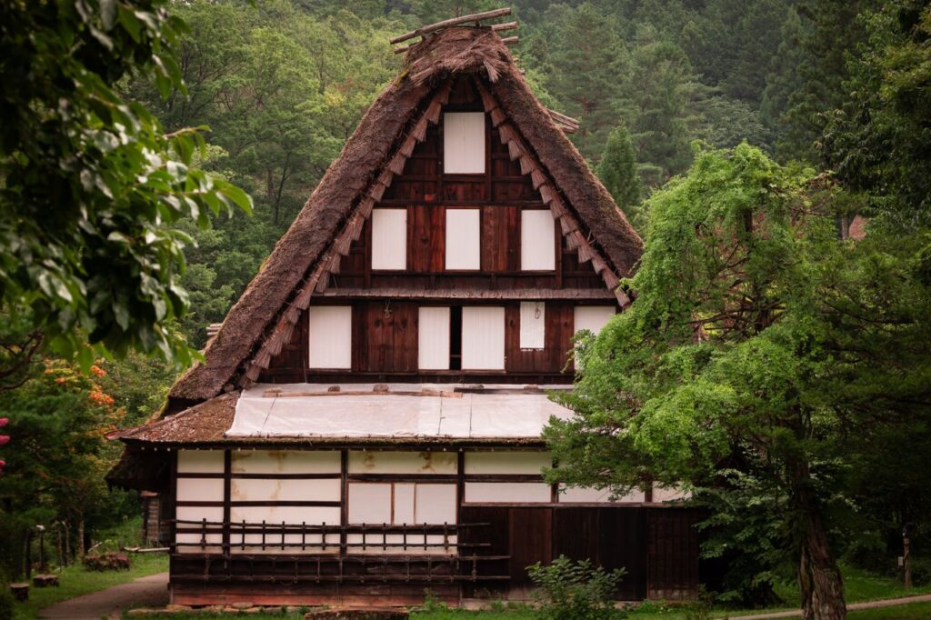 Trip Search Result Scenic view of historic Gassho-Zukuri farmhouse surrounded by lush greenery in Takayama, Japan.