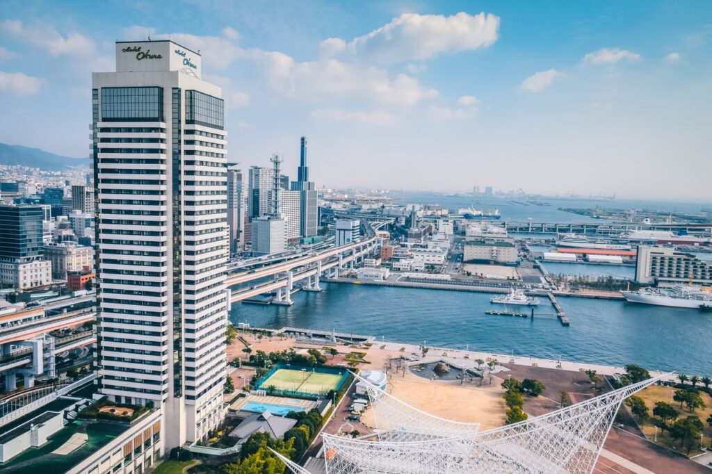 Trip Search Result Elevated view of Kobe cityscape featuring modern architecture along the waterfront.