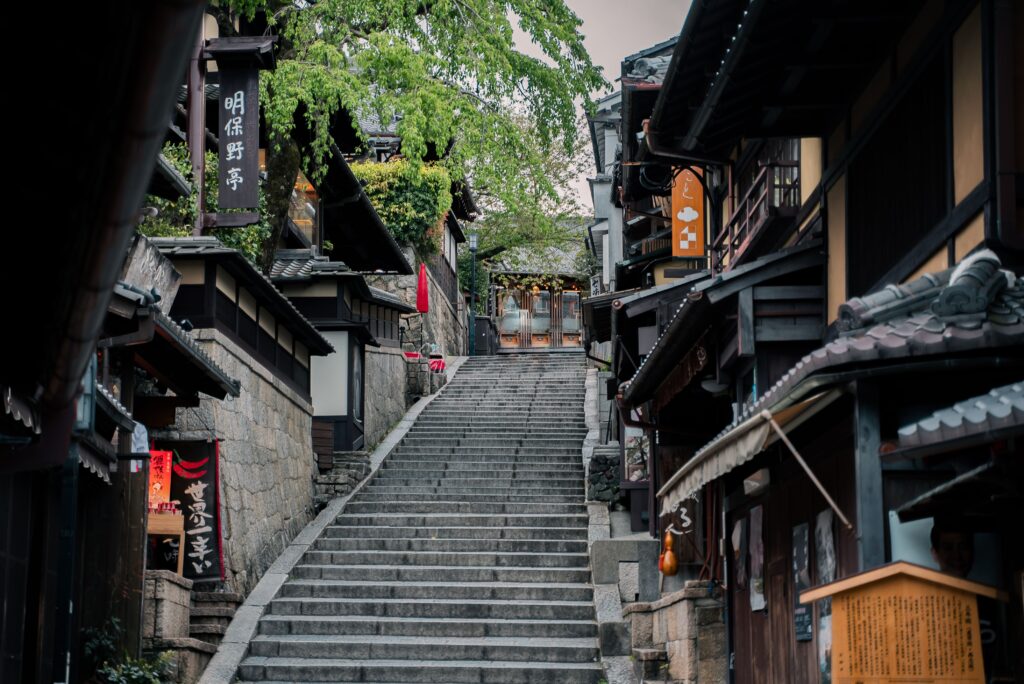 Trip Search Result Charming historic street in Kyoto featuring traditional wooden buildings and a stone staircase.