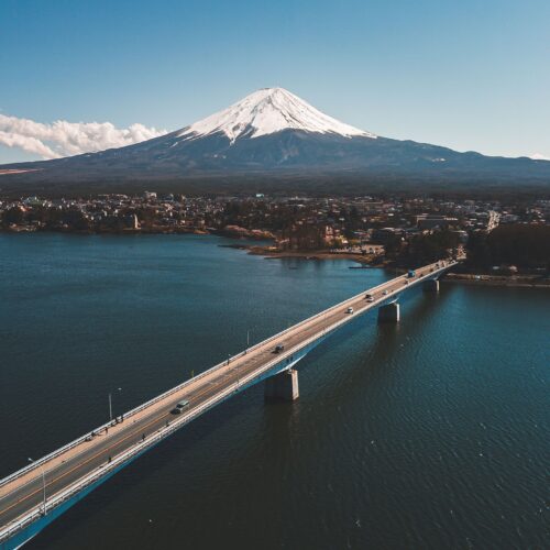 Stunning aerial view of Kawaguchiko Bridge with majestic Mount Fuji in the background.