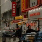 Vibrant Shinjuku street scene featuring neon signs and vendors bustling with activity at night.