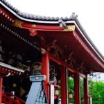 Detailed view of the vibrant red architecture of Senso-ji Temple in Tokyo, Japan.