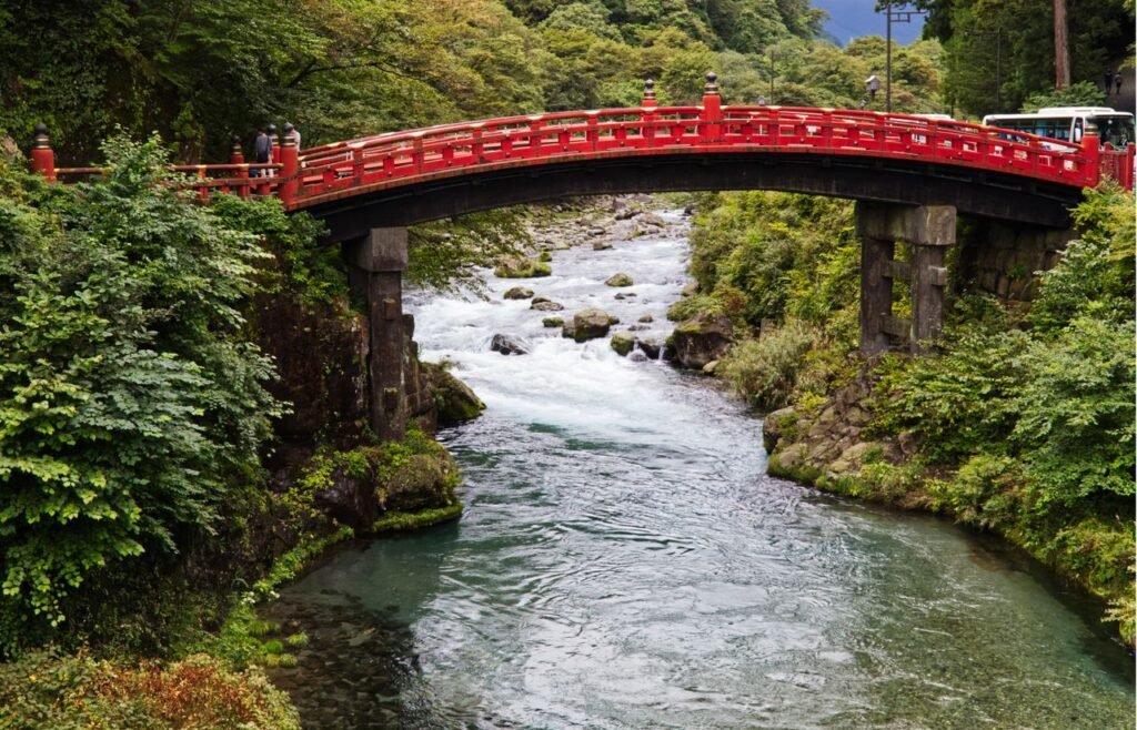 Beautiful Shinkyo Bridge over Daiya River in lush Nikko landscape.