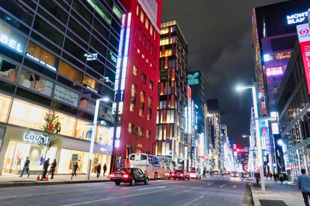 Vibrant cityscape of Ginza, Tokyo featuring colorful high-rise buildings lit up at night.