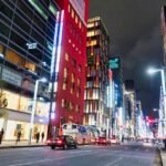 Vibrant cityscape of Ginza, Tokyo featuring colorful high-rise buildings lit up at night.